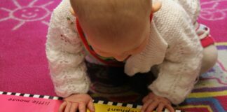 Nati per Leggere: in Biblioteca a Caorle un incontro del Corso Post Parto VeneziaOrientale@news: bimo che guarda ul libro illustrato