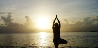 Bibione Olistic Festival VeneziaOrientale@news: una donna pratica yoga sulla spiaggia