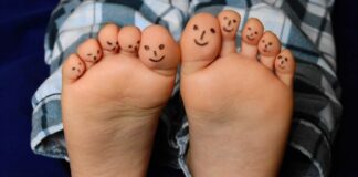 Storie sotto i piedi nel giardino della Biblioteca di Portogruaro VeneziaOrientale@news: piedi di bimbo con disegnate le faccine