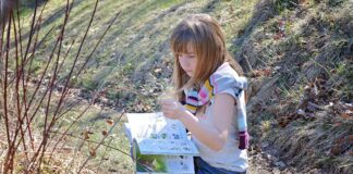 Alla Primaria Vivaldi di San Giorgio di Livenza si farà Outdoor education VeneziaOrientale@new: una bambina con un libro in un prato