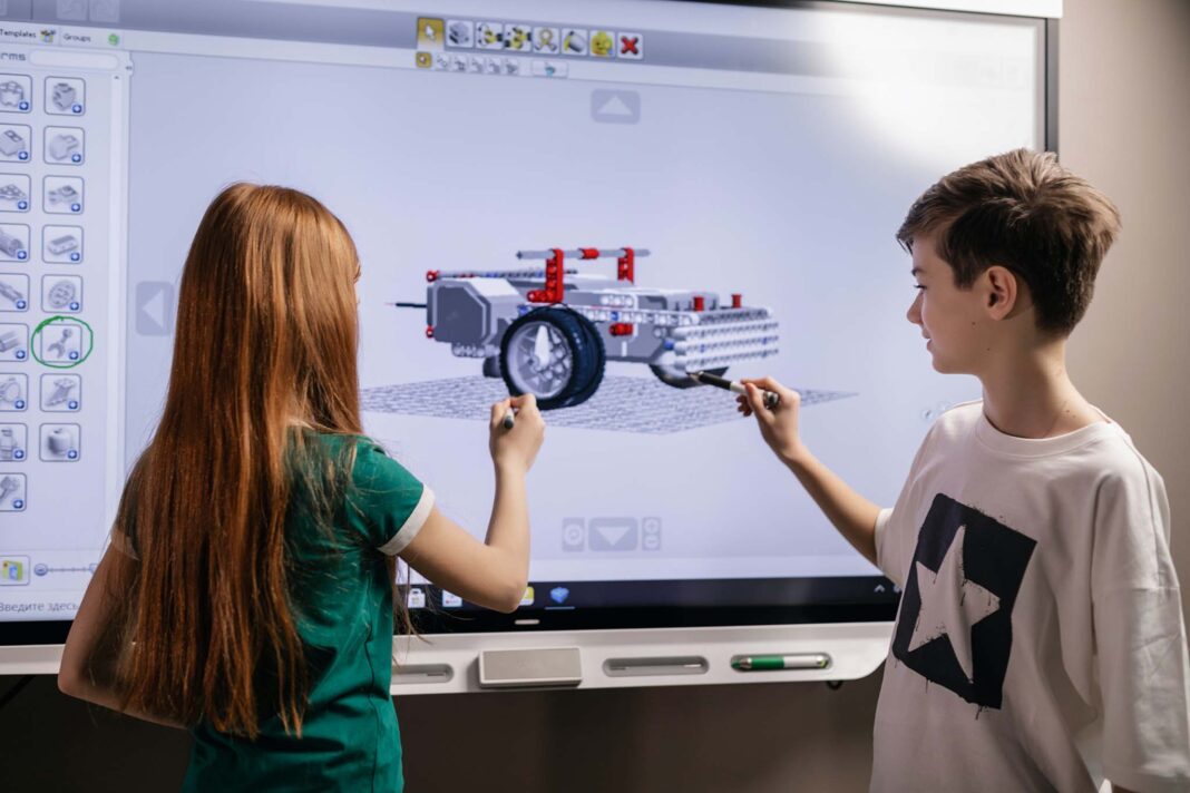 Bambini di fronte ad uno schermo con un progetto 3D