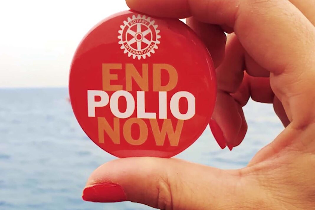 Una mano tiene una spilla di End Polio Now