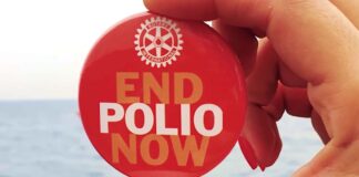 Rotary e Rotaract insieme per End Polio Now Una mano tiene una spilla di End Polio Now