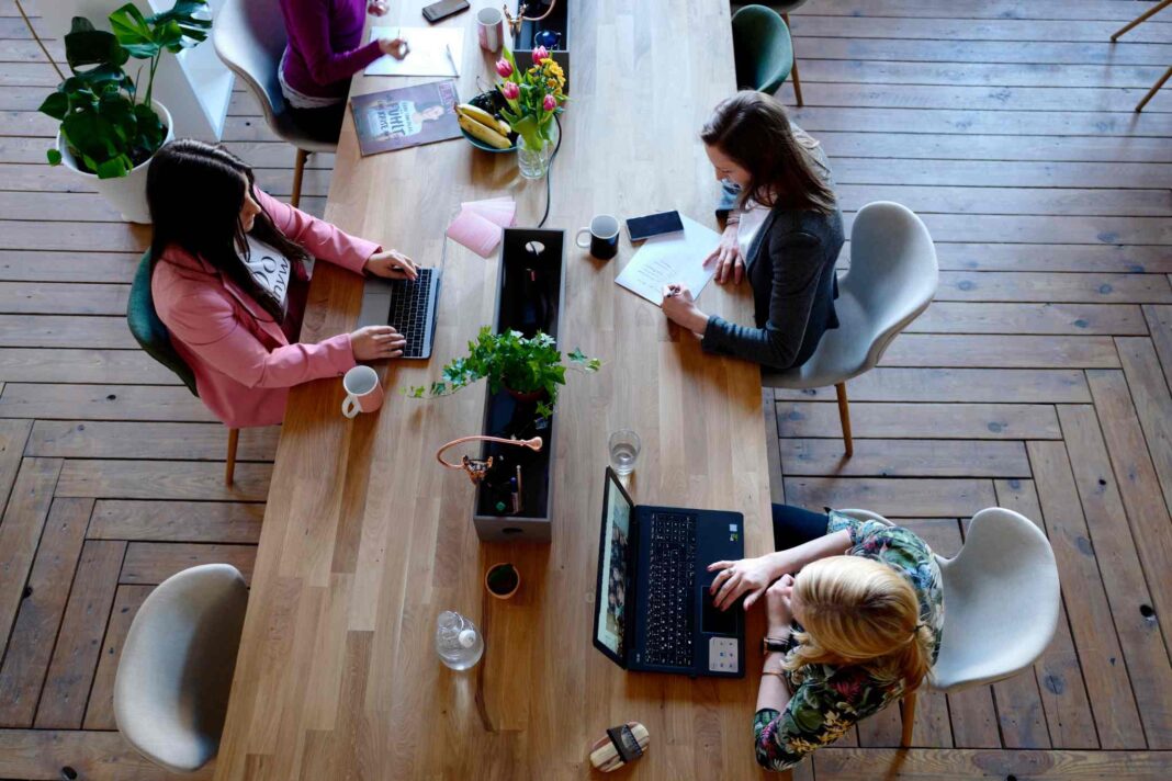 Foto di Canva ad uso gratuito che ritrae delle persone lavorare contemporaneamente in uno stesso spazio. Foto utilizzata per articolo che tratta il coworking a Treviso